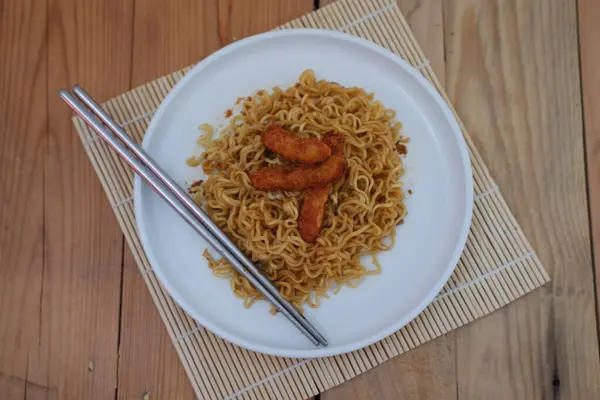 Üstü nuggetla kaplı bir tabak şehriye lezzetli ve renkli bir yemek yaratıyor..