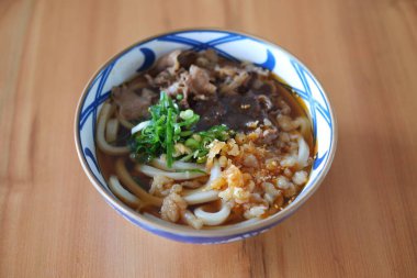 Tahta arka planda kasede sığır etli erişte..