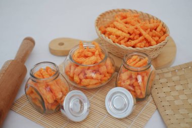 Tahta sepetin içinde gevrek mısır gevreği ve bambu hasırında kavanoz.