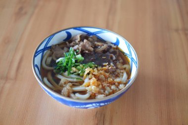 Tahta arka planda kasede sığır etli erişte..