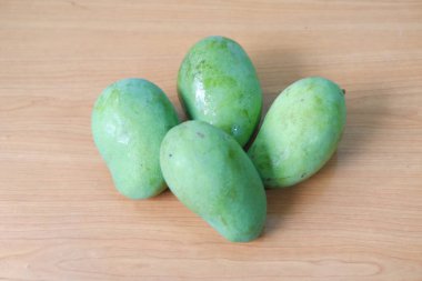 Ahşap arka planda mango meyvesi, yeşil mango meyvesine yakın plan