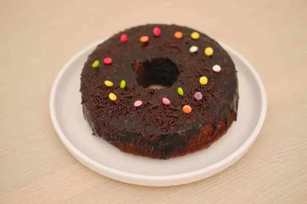 Tabakta çikolatalı kek ve ahşap arka plan.