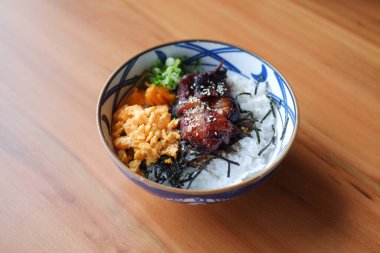 Renkli ve iştah açıcı malzemelerle süslenmiş Japon usulü güzel bir kase pirinç.
