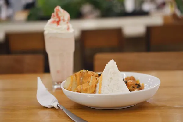 Buharda pişirilmiş üç köşeli bir pirinç tepeciği. Bol portakallı kremalı soslu kızarmış tavuk parçaları. Peynir ya da baharatlı mayonez karışımı.