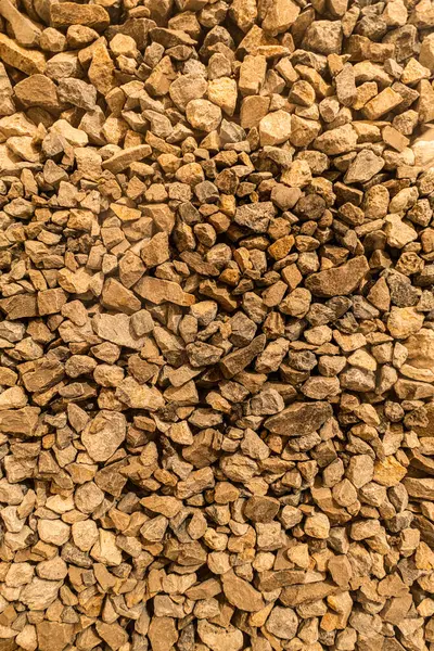 Kahverengi ezilmiş taş yığını, pürüzlü çakıl dokusu, yakın çekim