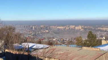 Smog over Bishkek, Kyrgyzstan. Panorama of the city of Bishkek from the observation deck. View of high-rise buildings, foundation pit and roofs of houses. The most polluted city in the world. The problem of ecology.
