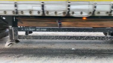 Big dirty truck wheels close up. The truck is driving on a snowy road. View of the wheels.