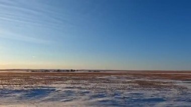 Beautiful panorama of the endless Kazakh steppe. Small village. Traveling by car along the highway in Kazakhstan. Warm sunny winter day. Calm calming natural background.