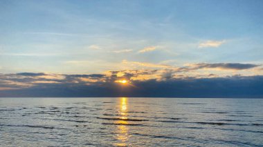Panorama of a beautiful blue lake at sunset. The pearl of Kyrgyzstan is Lake Issyk-Kul. Amazing summer landscape. Calm calming natural background.