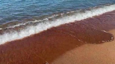 View of the sandy seashore with an incoming wave. A calm, peaceful background. Beautiful seascape.