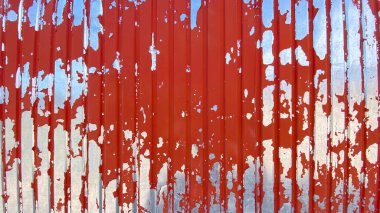 Çizgili galvanizli çatı örtüsü, kırmızı boya ya da kanla boyanmış. Doku eski gümüş çelikten yapılma kıvrımlı demirden yapılmış ve kırmızı bir güzelliği var. Demir çit duvar.