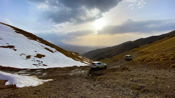 2台の車の峠の山の中で高い駐車されます 美しい山の風景 雪の山 緑の丘や夕日の空キャップ キルギスの素晴らしい自然 — ストック写真