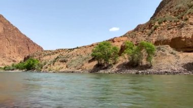 Resimli bir dağ gölü. Güzel bir vadi manzarası. Kırgızistan 'ın şaşırtıcı doğasına sahip taşlı bir nehir manzarası..