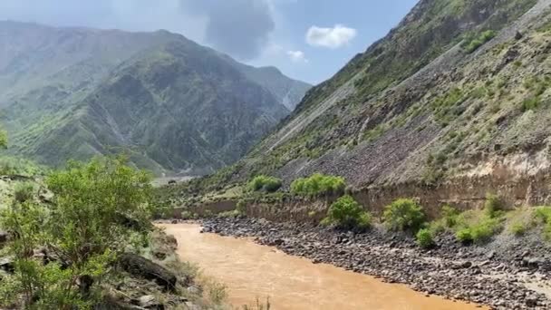 从一条肮脏的褐色风暴河流的高处眺望 吉尔吉斯斯坦一个山谷的美丽全景 神奇的山景 蓝天白云青山 — 图库视频影像