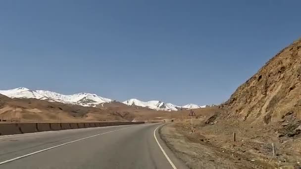 在吉尔吉斯斯坦开车旅行 俯瞰白雪覆盖的高山 山脊和柏油路 美丽的沙漠山脉风景 令人激动的道路冒险 — 图库视频影像