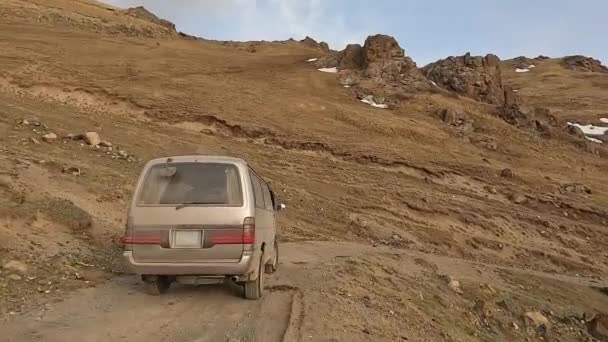 Minivan Jedzie Górską Skalistą Drogą Ośnieżone Góry Wzgórza Ekscytująca Przygoda — Wideo stockowe
