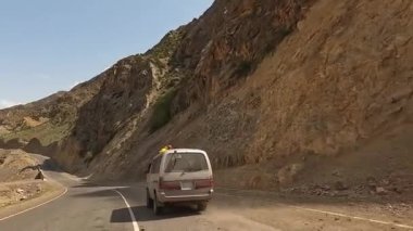 Adam minivanın çatısından eğildi, etrafındaki güzelliğe baktı. Muhteşem yaz dağ manzarası. Heyecanlı bir dağ yolu macerası.