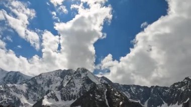 Karla kaplı sıradağlar, tepeler, yamaçlar ve uçurumların muhteşem manzarası. Altai, Rusya 'nın güzel doğası. Belukha 'ya tırmanmak. Görkemli dağların manzarası. Mavi gökyüzü ve beyaz bulutlar.