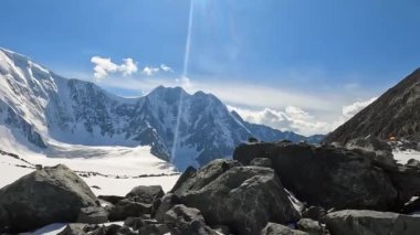 Belukha yakınlarındaki ana kamptaki görkemli Altai dağlarının panoraması. Karla kaplı sıradağlar, tepeler, yamaçlar ve uçurumların muhteşem manzarası. Rusya 'nın güzel doğası. Belukha 'ya tırmanmak. Mavi gökyüzü ve beyaz bulutlar.