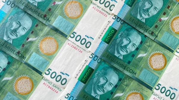 キルギスの国の通貨の背景 5000ドルのキャッシュバンク 俳優のスイメンスク チョコモロフ 現在のキルギスタンの貨幣 の肖像画を持つ5000人のグリーン紙幣 金融ビジネス背景コンセプト — ストック写真