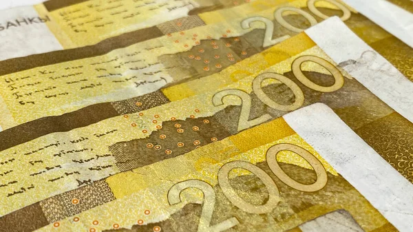 現金の紙幣は200ドルから 黄色200ソムノートの一部 現在のキルギスタンのお金のクローズアップ キルギスの通貨 金融ビジネス背景コンセプト — ストック写真