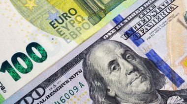 Döviz bürosu. 100 euro ve 100 dolarlık banknotlar çapraz olarak yatıyor. Yüz avroluk banknotlar ve yüz Amerikan doları. Ekonomi ve finans. ABD ve Avrupa Birliği 'nin nakit banknotları. Paranın arka planı.