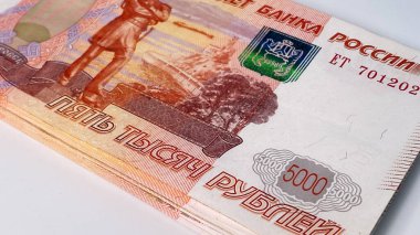 Beş bin rublelik banknot beyaz bir masanın üzerinde duruyor, yakın plan. 5000 rublelik banknotlar. Rusya Bankası 'nın biletleri. Ekonomi ve finans. Nakit para. Para geçmişi var. Rus ulusal para birimi.