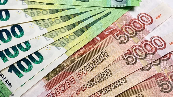 通貨交換について 100ユーロと5000ロシアルーブルのいくつかの紙幣 100ユーロと500ルーブルの紙幣 経済と金融 ロシアとEuの現金紙幣 お金の背景について — ストック写真