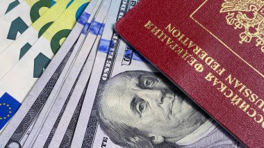 100 dolarlık banknotlar, 100 avro ve Rusya Federasyonu 'nun yabancı pasaportu. Amerikan ve Avrupa ulusal para birimleri. Yakın plan. Nakit para. Finansal iş geçmişi kavramı.