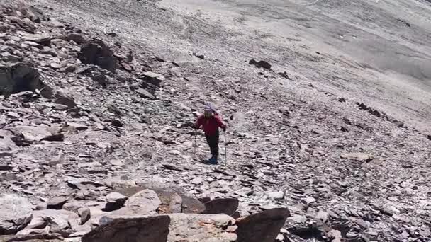 一个带着小背包和远足杆子的人沿着山路走着 吉尔吉斯斯坦阿拉阿卡国家公园 山区景观 — 图库视频影像