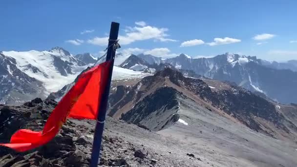 吉尔吉斯斯坦的国旗正飘扬在Komsomolets山顶 吉尔吉斯斯坦阿拉阿卡国家公园 吉尔吉斯斯坦山岭的白雪覆盖的山脉 斜坡和山峰 — 图库视频影像