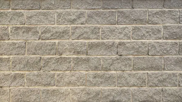 Duvar eski püskü gri taştan yapılmış. Tuğla harap olmuş duvar işçiliği. Soyut arkaplan.