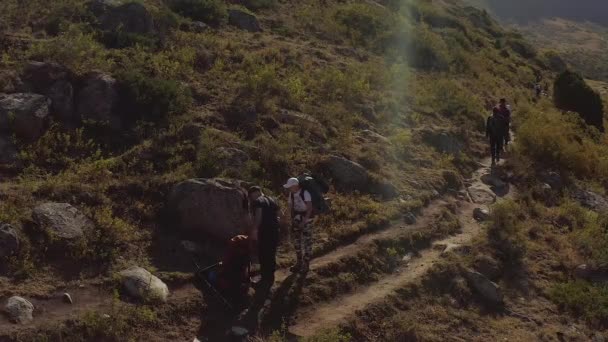 那家伙把一个大的旅行背包 一群游客在远处 吉尔吉斯斯坦的阿拉阿卡国家公园 神奇的山景 积极休闲 — 图库视频影像