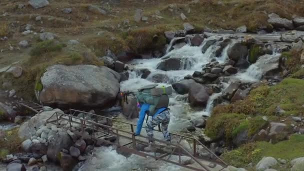 Μια Τουρίστρια Ένα Μεγάλο Σακίδιο Διασχίζει Ένα Θυελλώδες Κρύο Ποτάμι — Αρχείο Βίντεο
