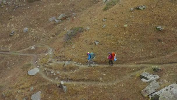 带着大背包的游客沿着山路走着 吉尔吉斯斯坦阿拉阿卡国家公园 美丽的山景 积极休闲 — 图库视频影像