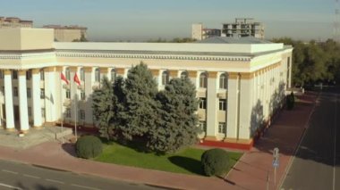 Kırgız Cumhuriyeti Hükümeti 'nin binasının yüksekliğinden bak. Sütunları ve kırgız bayrakları rüzgarda dalgalanan güzel bir bina. Bir tarih ve mimari abidesi. Bishkek şehrinin idari binası.