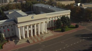 Kırgız Cumhuriyeti 'nin hükümet binasının en üst görüntüsü. Kırgız bayrakları rüzgarda dalgalanıyor. Bishkek şehrinin idari binası. Bir tarih ve mimari abidesi..