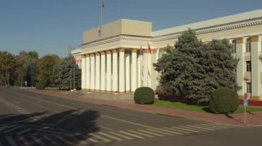 Kırgız Cumhuriyeti Hükümet Binası 'nın alt manzarası. Kırgız bayrakları rüzgarda dalgalanıyor. Bishkek şehrinin idari binası. Bir tarih ve mimari abidesi..