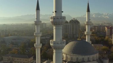 Merkez Bişkek Camii 'nin dört minaresine yakın çekim. Orta Asya 'nın ikonik İslami yapısı. Orta Asya ve Kırgızistan 'daki en büyük cami. Arka planda dağ zirveleri.