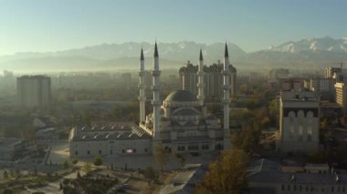 Orta Asya ve Kırgızistan 'daki en büyük cami olan Merkez Cami' nin minarelerinden birine insansız hava aracı yaklaşımı. Uzakta karla kaplı dağ zirveleri. Bishkek 'in en önemli eğlencelerinden biri. Orta Asya 'nın ikonik İslami yapısı.