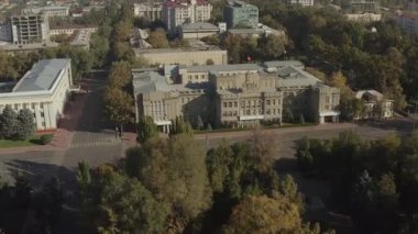 Kırgız Cumhuriyeti Yüksek Mahkemesi 'nin binası yeşil ağaçlarla çevrilidir. Bayrak direğindeki Kırgızistan bayrağı. Sivil, suç, ekonomi, idari ve diğer davalar için yüksek yargı organı.