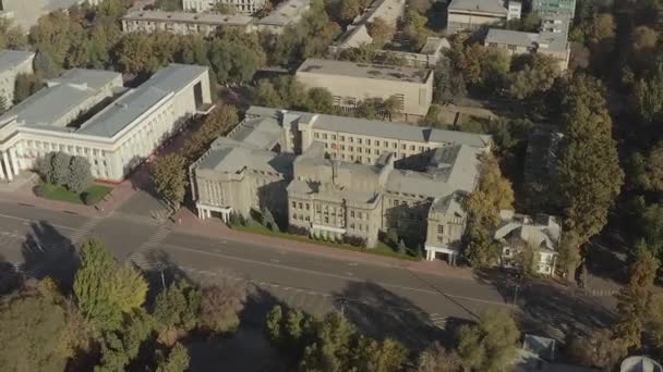 緑の木に囲まれたキルギス共和国の最高裁判所の建物の鳥の目視 フラッグポールのキルギスの旗 その他の事件のための最高司法機関 — ストック動画