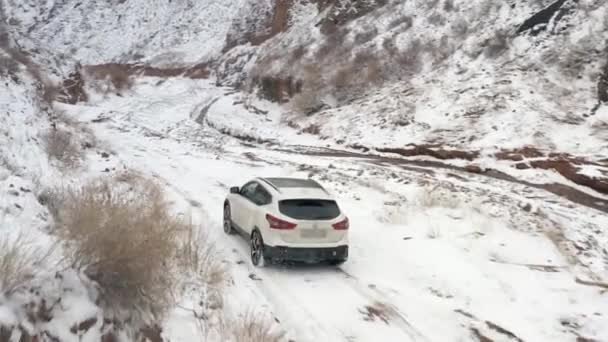 白い車が美しい山の谷 雪に覆われた山道を走っています キルギス コノルチェクキャニオンで車で旅行する 美しい冬の風景 — ストック動画