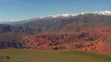 Konorchek Kanyonlarının kuş bakışı görüntüsü. Kırgızistan 'ın çarpıcı dağlarında yolculuk. Güzel dağ yaz manzarası. Uzakta karla kaplı dağ zirveleri. İnanılmaz tepeler, tepeler ve uçurumlar üzerinde İHA uçurmak
