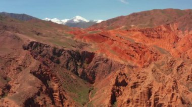 Tien Shan Dağları. Kırgızistan 'da güzel bir dağ vadisi. Konorchek Kanyonlarının muhteşem manzaraları. Harap olmuş kayalık kumlu kırmızı oluşumlar, erozyona eğilimli. Görkemli kil heykeller