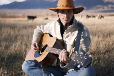 Genç düşünceli bir çoban elinde gitarla kuru otların arasındaki bir tarlada oturuyor. Kovboy şapkalı bir adam bir tarlada gitar çalıyor. Yalnız bir gitarist Kırgızistan dağlarında inekleri otlatıyor. Bir çiftçinin çiftliği.