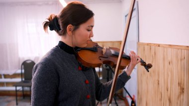 Güzel genç bir Asyalı öğrenci keman çalmayı öğreniyor. Genç bir kadın bir müzik okulunda keman çalıyor. Müzisyen yeni bir melodi besteler. Provadaki kemancı
