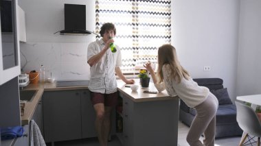 Bir adam genç bir kadını evine davet etti. Genç bir çift mutfak masasında duruyor. Kocası alkolik. Ailede sorunlar var. Kadın beyaz bir gömlek giyiyor ve erkek şort giyiyor. Sahne rahat.