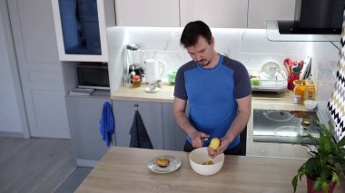 Çiğ patates soyan yalnız bir gencin manzarası. Lezzetli bir öğle yemeği pişiriyorum. Öğrenci hayatı. İnsan kızarmış patates pişirmeyi öğreniyor.