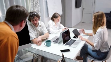 Şirket yöneticisi, çalışanların geri kalanı dizüstü bilgisayarlar ve cep telefonları üzerinde çalışırken patronla önemli bir konuyu tartışıyor. Birlikte bir proje üzerinde çalışıyorlar..